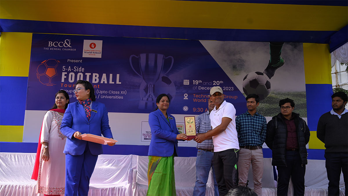 Ms. G Jayashree, Headmistress, Techno India Group World School handing over a memento to a coach